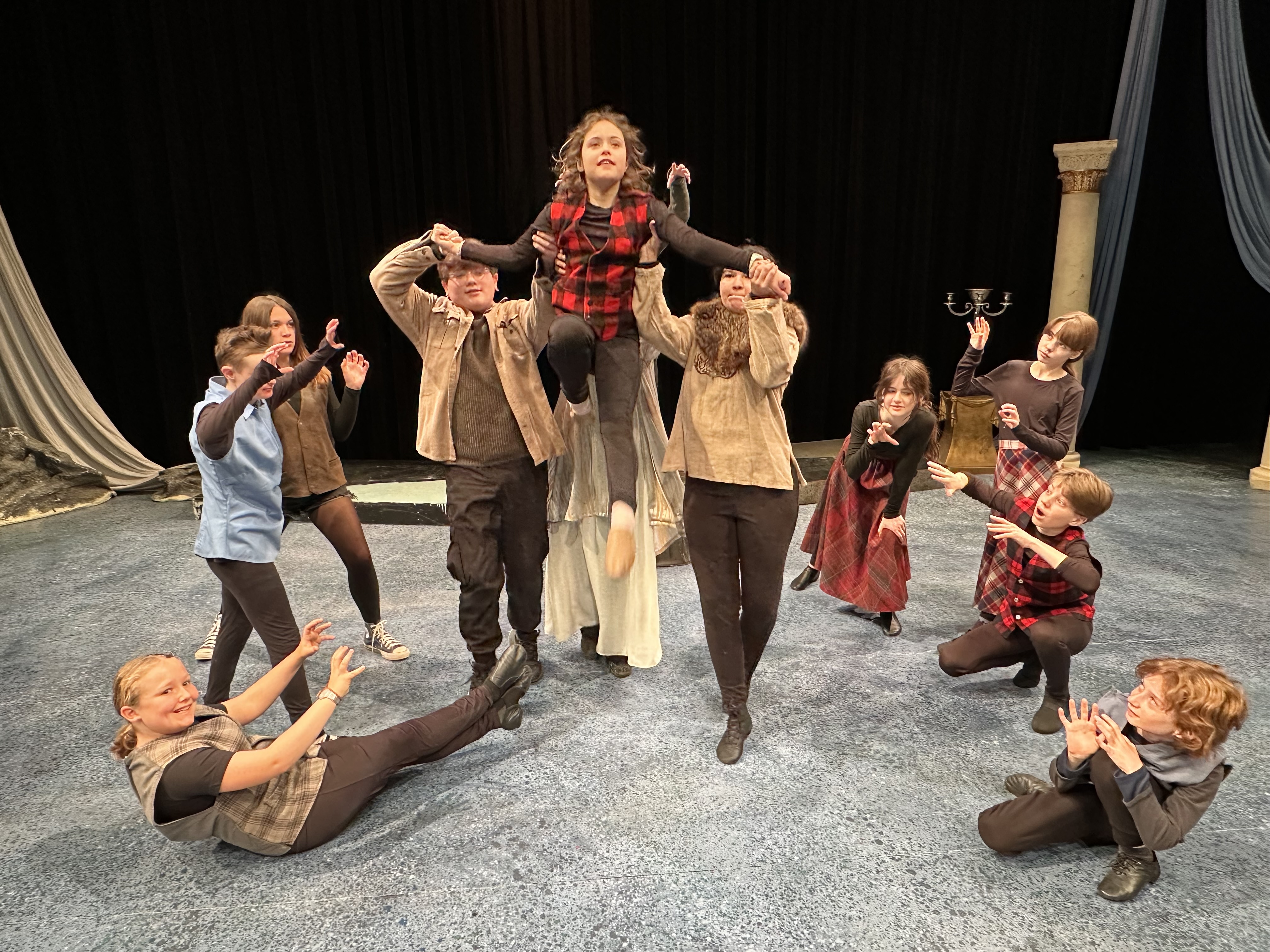 students, coached by Taryn Noelle, lift another student (lying perpeniduclar to the floor) in a dance
