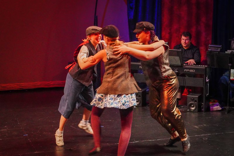 a moment from Seize the Day where actor/dancers unite in circle wearing newscaps and vests
